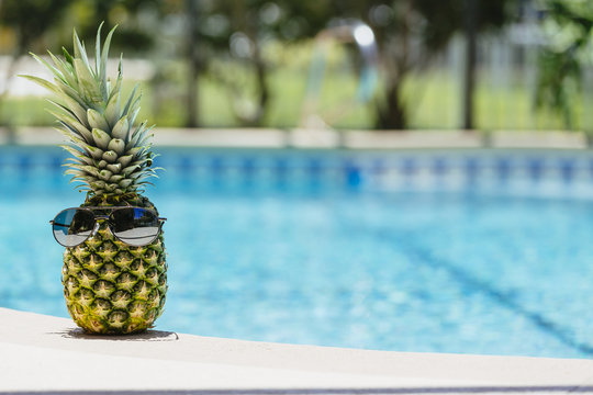 A pineapple relaxing by the pool