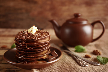 Tasty pancakes with chocolate sauce on plate
