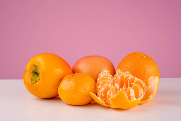 Fresh fruit mandarin, persimmon tangerine and orange on a table