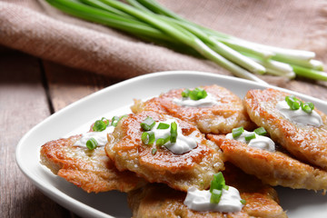 Plate with tasty potato pancakes for Hanukkah on wooden table, closeup