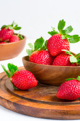 Ripe strawberries in a large wooden bowl, selective focus