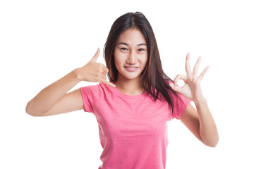 Young Asian woman show with phone gesture and OK sign..