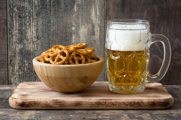 Pretzels in bowl and beer on wooden table
