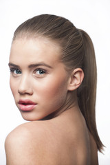 Face of a blond young woman teenager green eyes ponytail