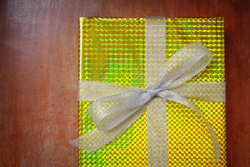 Top view of gift box wrap and ribbon with gold foil shiny wrappi