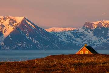 A house in front of snowy mountains