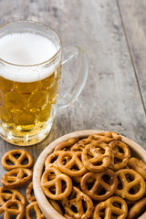 Pretzels in bowl and beer on wooden table

