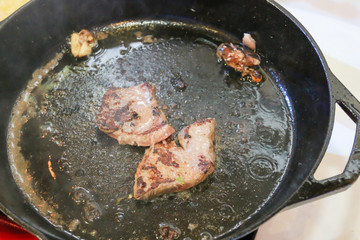 Raw beef meat steak grilling in a fry pan