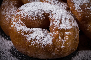 Sprinkling sugar powder on donut