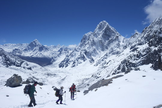 Trekkers walking over Cho La Pass with Ama Dablam on left and Arakam Tse on right, Solukhumbu District, Nepal, Himalayas 