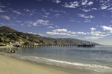 Malibu beach scene with pier, mountains background