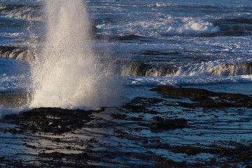 waves crashing on the lava rock bluffs