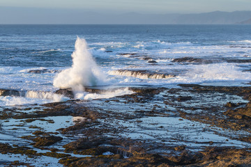 waves crashing on the lava rock bluffs