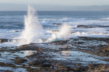 waves crashing on the lava rock bluffs
