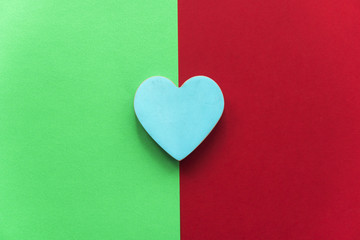 blue wooden heart on colorful background of green and red vinous color