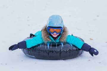 Girl with helmet and goggles riding the mountain winter day