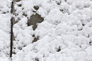 Snow on the wooden fence as a backdrop