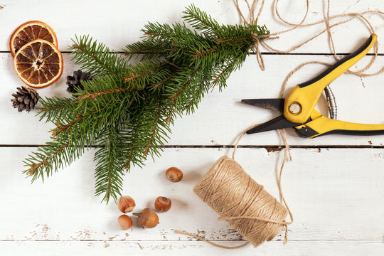 Christmas and New Year background. Elements for making Christmas decor. Fir tree, rope, scissors, cones, dried tangerines, nuts