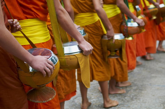 Procession of Buddhist monks collecting alms and rice at dawn, Luang Prabang, Laos