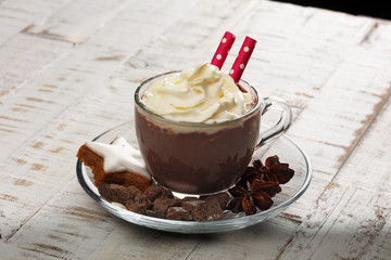 Hot chocolate cocoa with whipped cream on vintage wooden background, selective focus