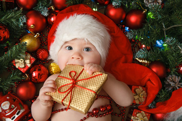 little girl in the hat of Santa Claus with gift - obrazy, fototapety, plakaty