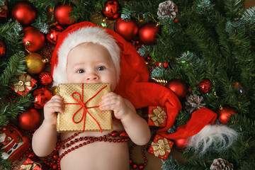 little girl in the hat of Santa Claus with gift