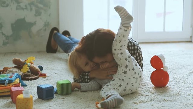 Mother plays with daughter on the floor