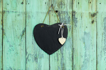 Blank slate heart hanging on rustic wood background