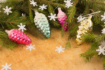 The branches of Christmas trees and  fallal cone decorations on the background of wooden boards and...