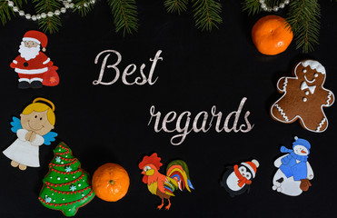 Xmas composition with text Best Regards on school blackboard and the Christmas decorations, toys (Santa Claus, Angel, a rooster, a snowman, a penguin) and tangerine