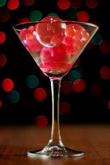 Christmas card: martini glass with balls on bokeh background