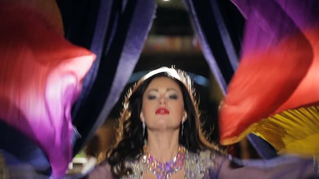 Portrait of Brunette woman dances belly dance with cloth.