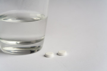 pills and glass of water on white background medicine pharmacy health