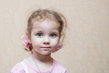 Fototapeta premium Portrait of a little girl with big blue eyes and curly hair