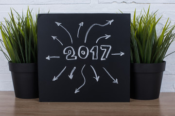 New Year 2017 on black chalk board and many arrows