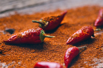Red chilli peppers, spicy on a wooden spoon. Vegetable on a dark, wooden table. Concept of hot...