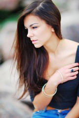 Portrait of a dreamy beautiful woman outdoors on blurred background, side view closeup.