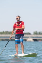 man enjoying a ride on the lake with paddleboard