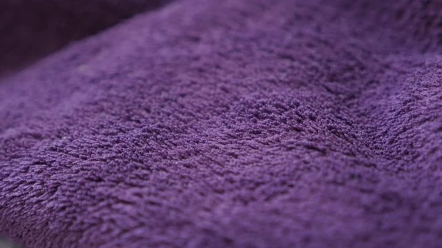 Synthetic fibers of warm violet blanket slow tilt 4K 2160p 30fps UltraHD footage - Decorative purple polar fleece close-up 3840X2160 UHD tilting video 