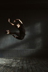 Fototapeta na wymiar Flexible young dancer performing in the air