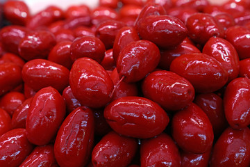 Red whole Cerignola olives in oil close up