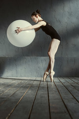 Sporty woman performing using the white balloon
