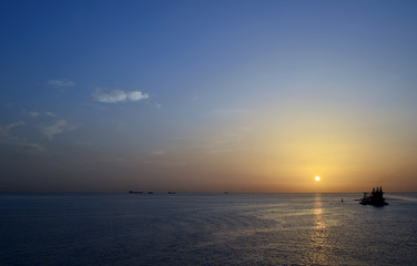 Fototapeta premium calm ocean sunset with boats