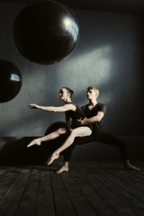 Positive involved ballet dancers stretching in the studio