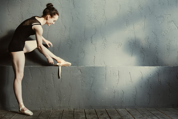 Positive ballet dancer wearing her points in the dancing saloon