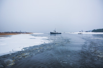 The russian Icebreaker tug boat ship trapped in ice tries to break free and leave the bay between the glaciers
