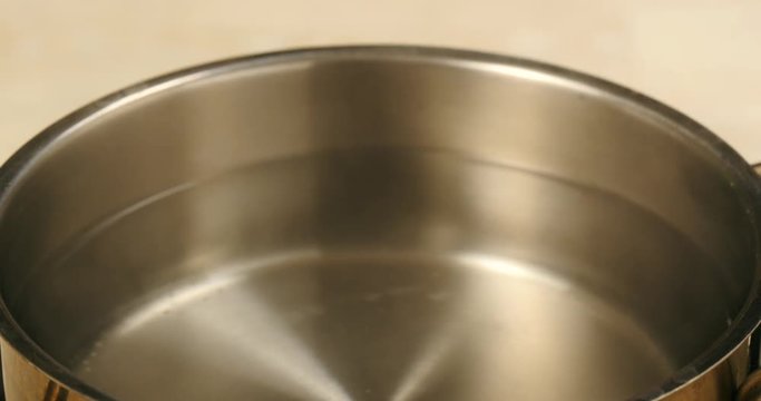 Steam of boiled water in stainless steel pot.
