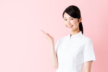 portrait of young asian nurse isolated on pink background