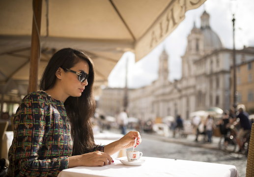 Young woman enjoying Espresso at restaurant, Piazza Navona, Rome, Lazio 
