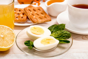 Healthy organic breakfast. Boiled eggs, cup of tea, orange juice